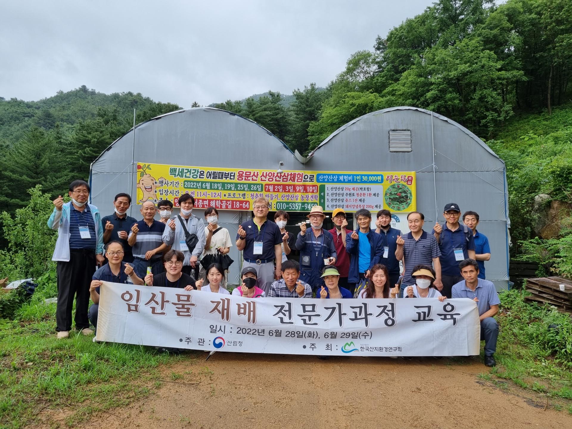 비닐하우스 앞에서 '임산물 재배 전문가과정 교육' 현수막을 들고 단체로 기념하는 모습 (2022년 6월 28~29일)