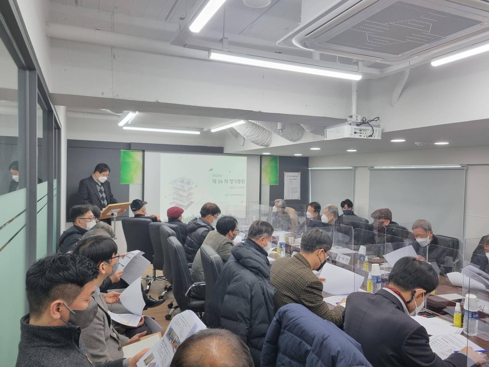 제26차 정기총회: 회원들이 대회의실에서 자료를 검토하며 회의하는 모습